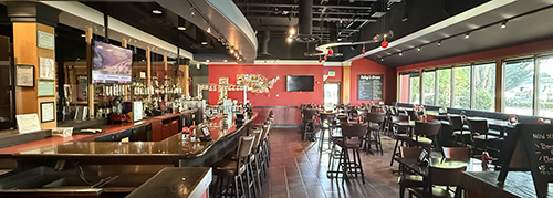 Entrance to the Red Robin bar with a long counter and tables beside large windows